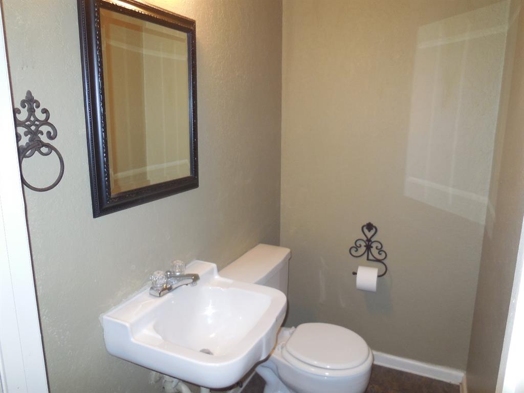 1220 Meadowbrook Street Ranger, TX 76470 - Photo 10 of 28 a bathroom with a sink mirror and toilet