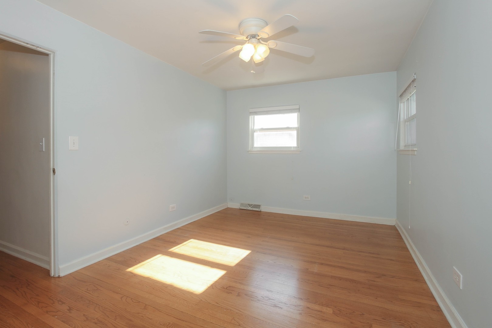 439 Elmhurst Road Mount Prospect, IL 60056 - Photo 12 of 24 a view of empty room with wooden floor and fan