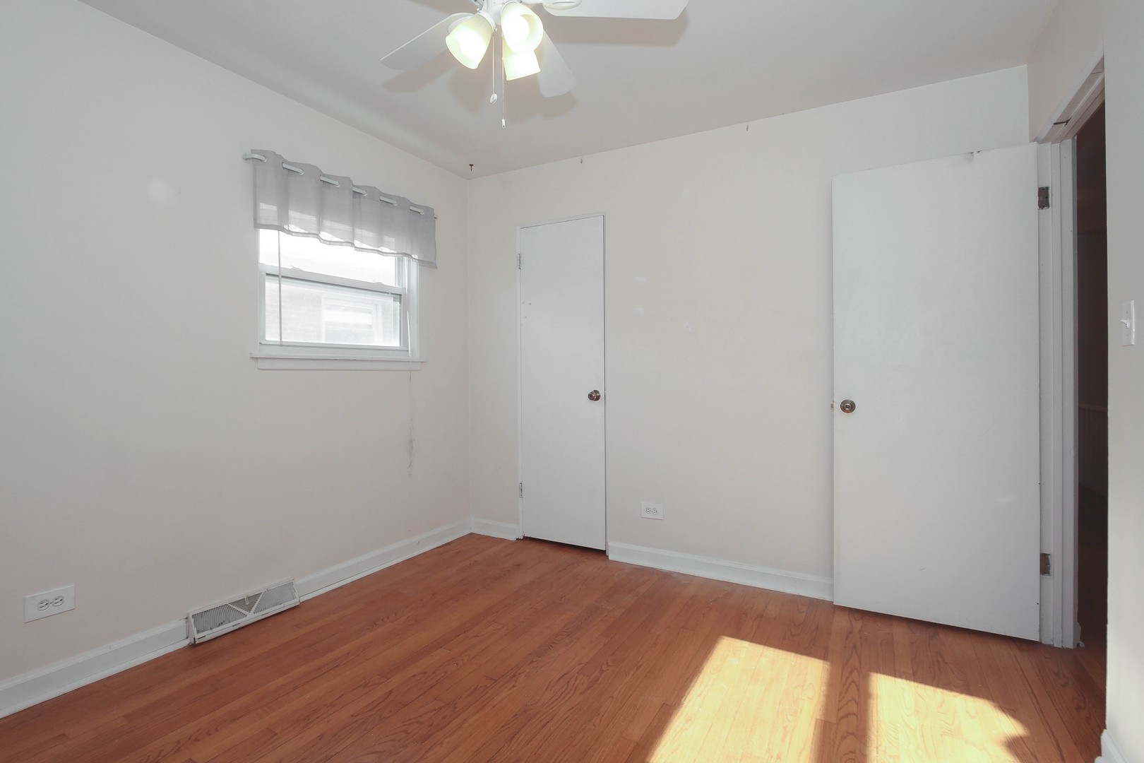 439 Elmhurst Road Mount Prospect, IL 60056 - Photo 18 of 24 a view of empty room with wooden floor and fan