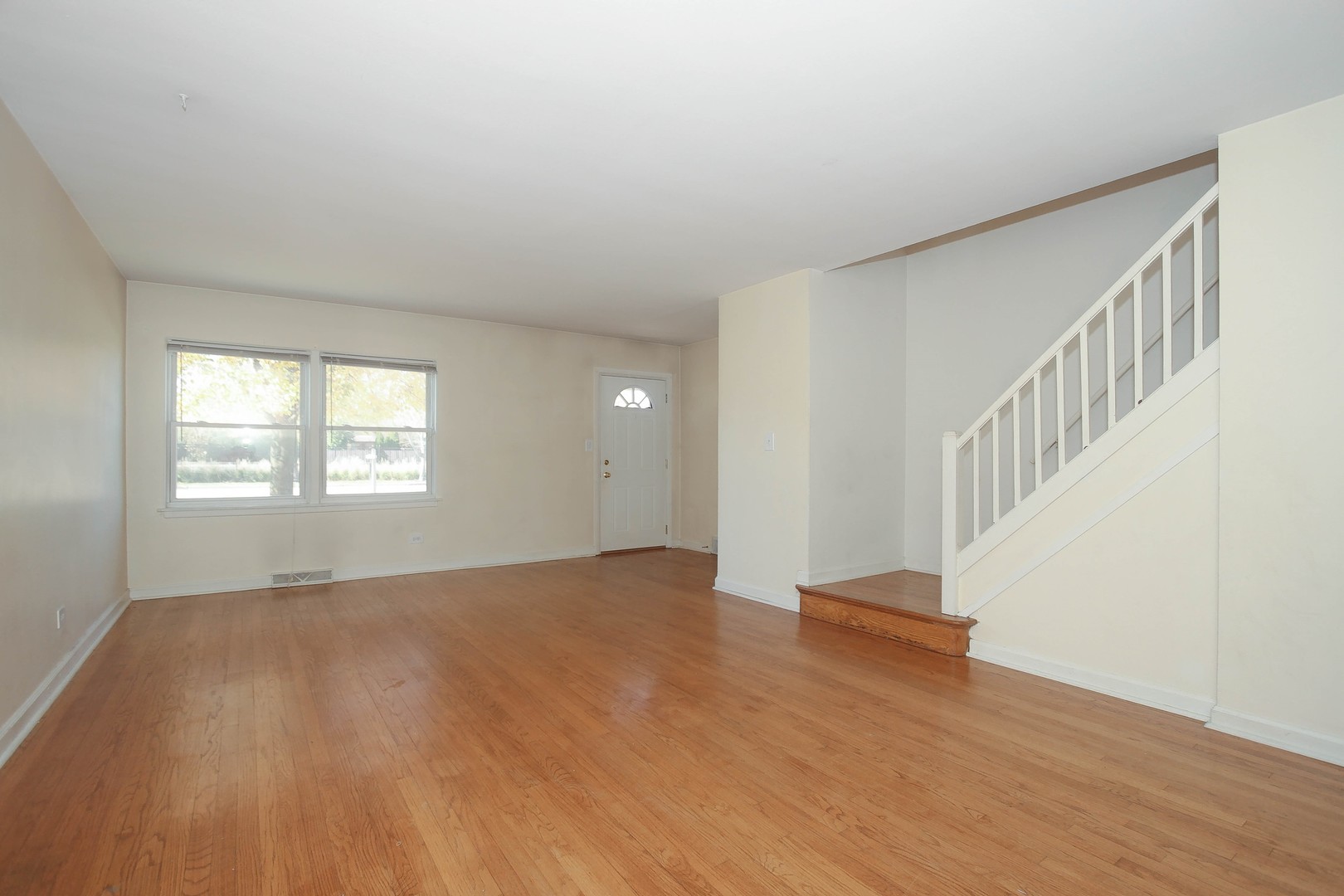439 Elmhurst Road Mount Prospect, IL 60056 - Photo 2 of 24 a view of an empty room with wooden floor and a window