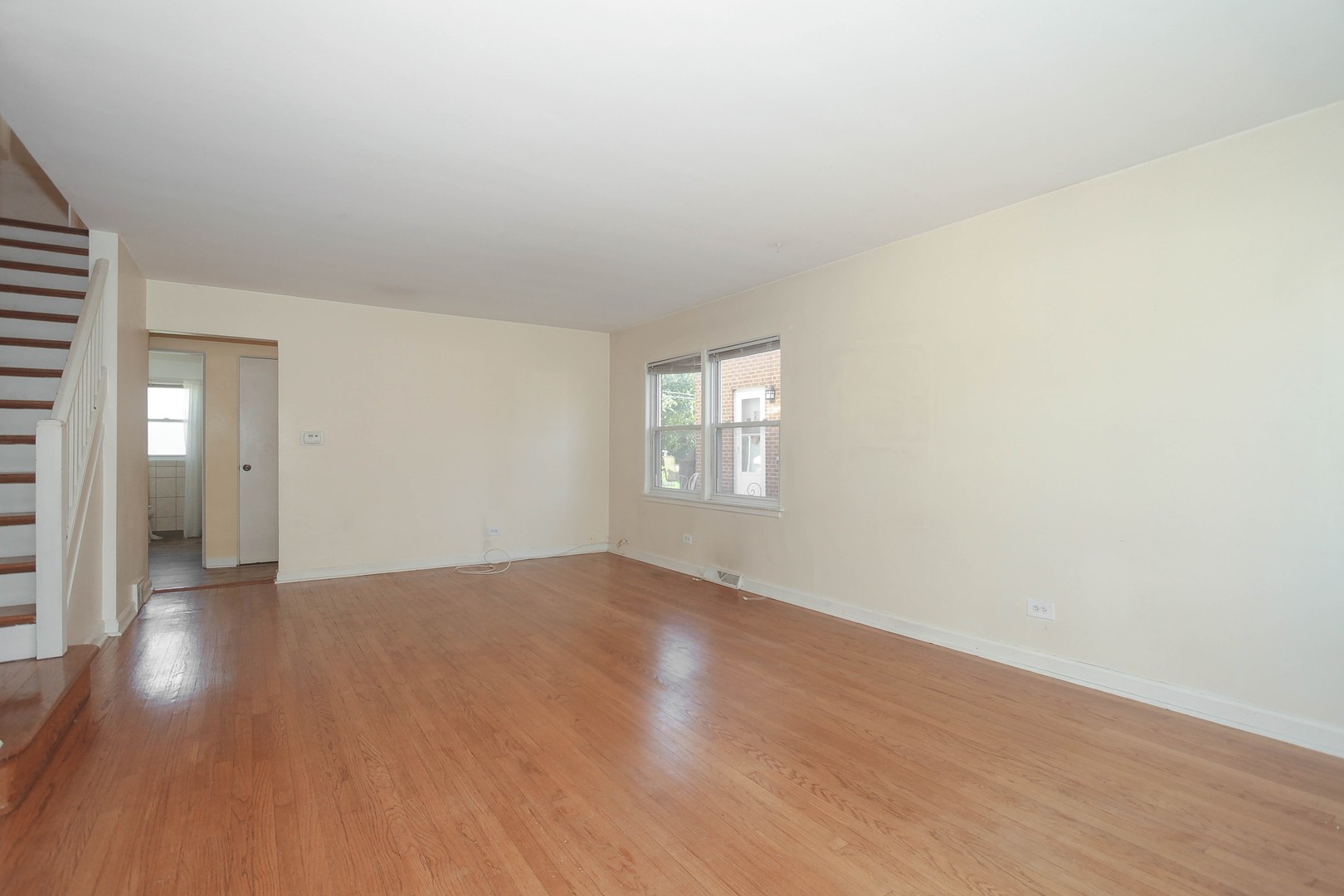 439 Elmhurst Road Mount Prospect, IL 60056 - Photo 3 of 24 a view of an empty room with wooden floor and a window