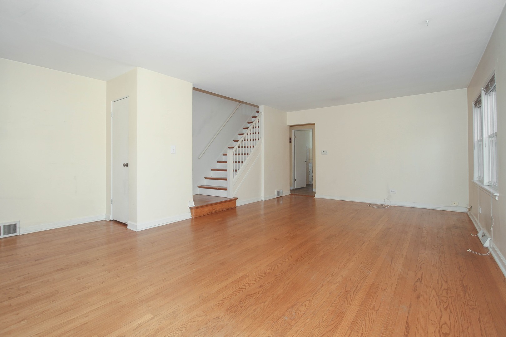 439 Elmhurst Road Mount Prospect, IL 60056 - Photo 4 of 24 an empty room with wooden floor and white walls