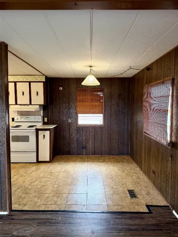 a kitchen with kitchen island granite countertop stove top oven and cabinets