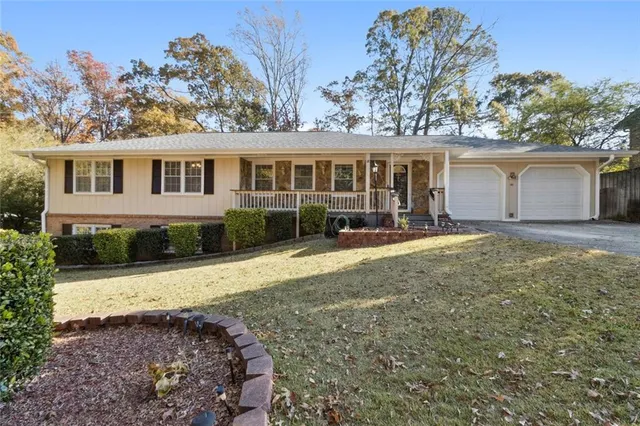 a view of a house with a yard and large tree