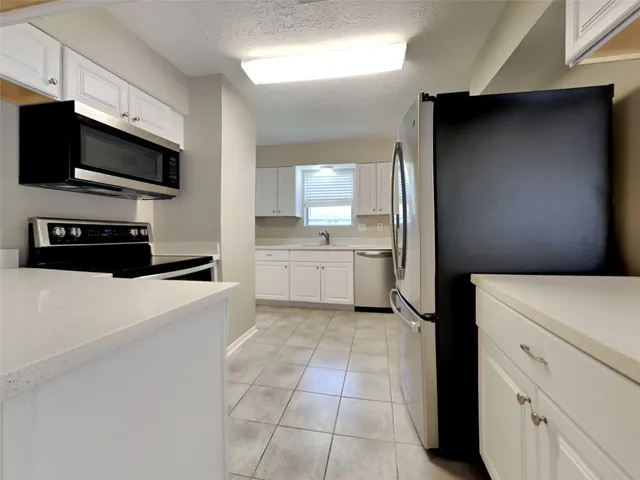 a kitchen with stainless steel appliances a refrigerator sink and microwave