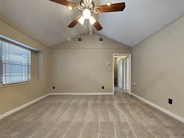 a view of an empty room with a chandelier fan