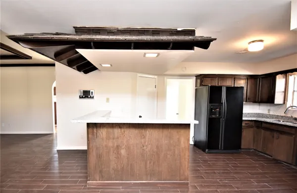 a kitchen with stainless steel appliances kitchen island a refrigerator sink and cabinets