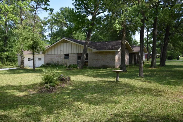 a house is sitting in middle od the grass