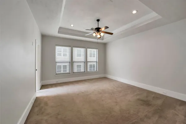 an empty room with a ceiling fan and windows