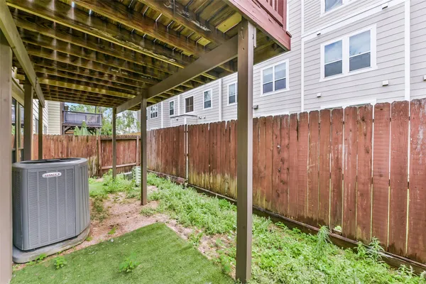a backyard of a house with lots of green space wooden fence and plants