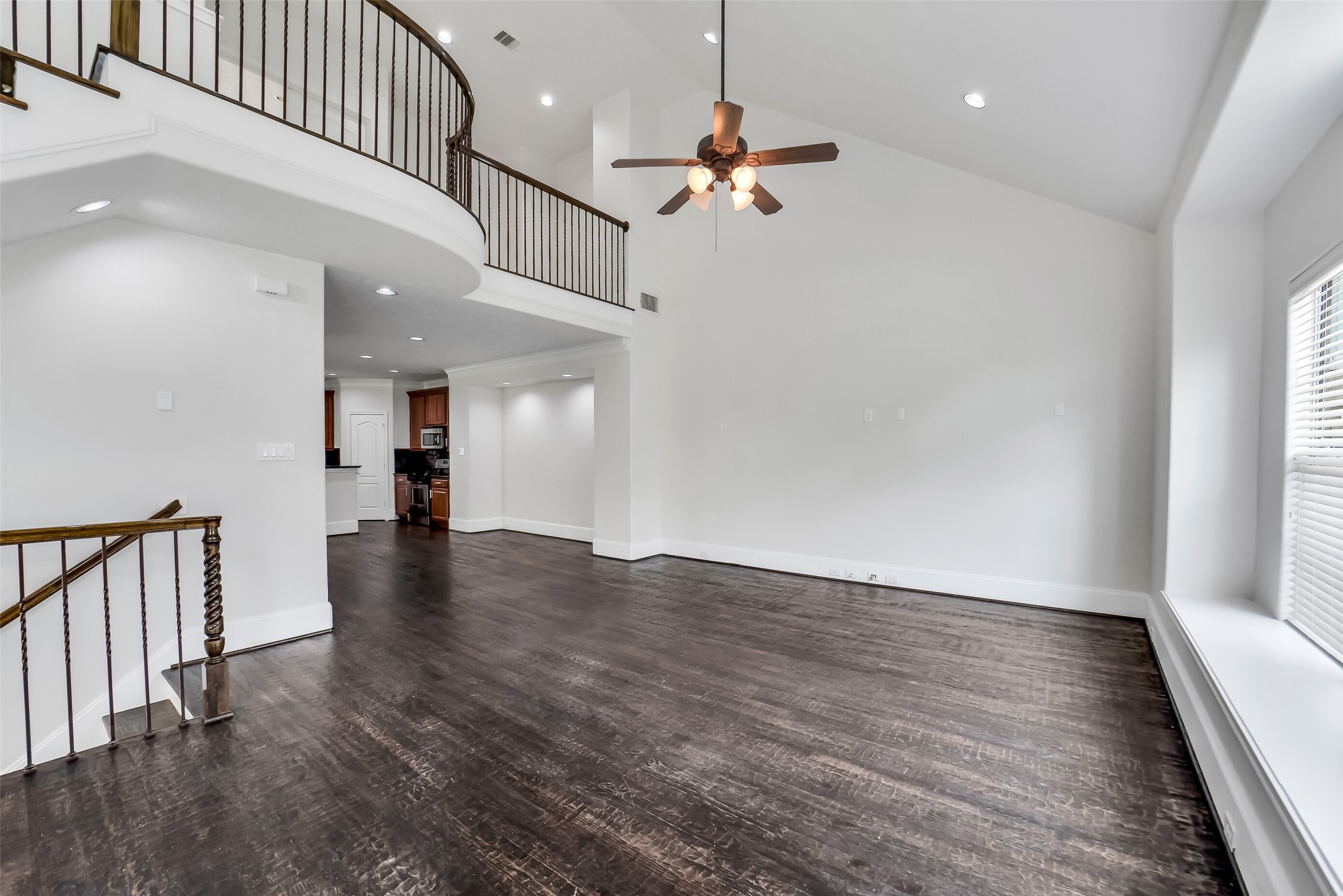 1335 Studer Street Houston, TX 77007 - Photo 7 of 37 an empty room with wooden floor ceiling fan and windows