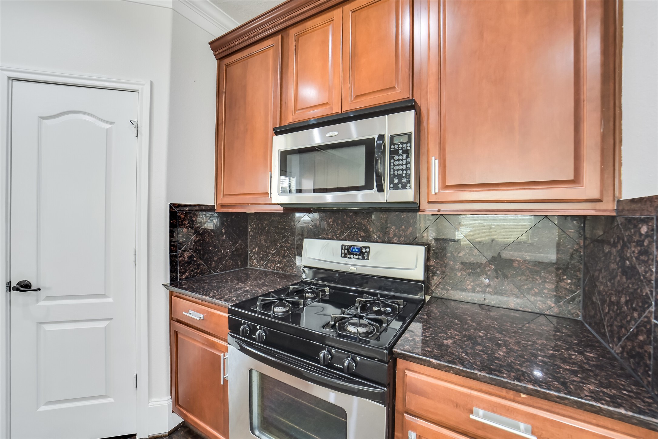 1335 Studer Street Houston, TX 77007 - Photo 10 of 37 a kitchen with granite countertop cabinets stainless steel appliances and a counter space