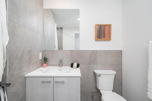 a bathroom with a sink a toilet and mirror