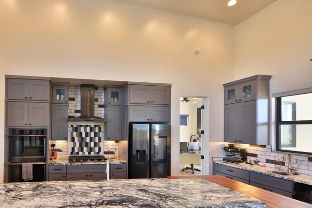 a kitchen with stainless steel appliances kitchen island granite countertop a refrigerator and stove