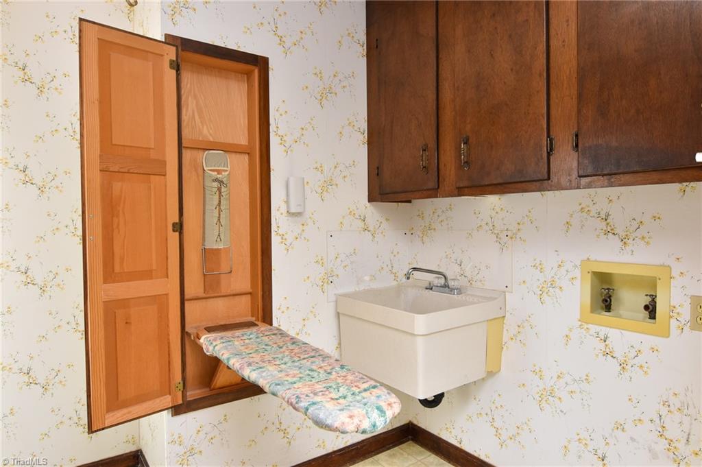 5959 Holder Road Clemmons, NC 27012 - Photo 28 of 40 Laundry Room on Main-level with built-in ironing board, cabinets and wash sink