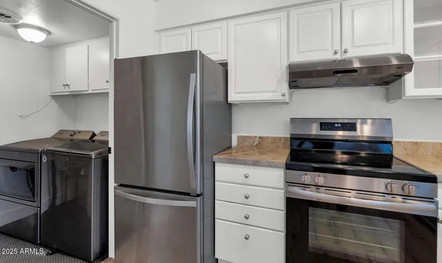 a kitchen with stainless steel appliances granite countertop a refrigerator and a stove