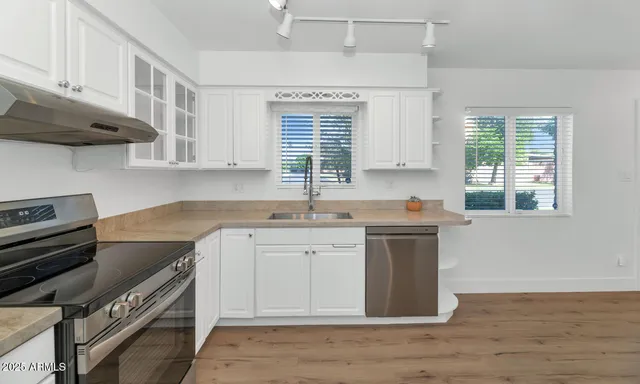a kitchen with a sink stove top oven and cabinets