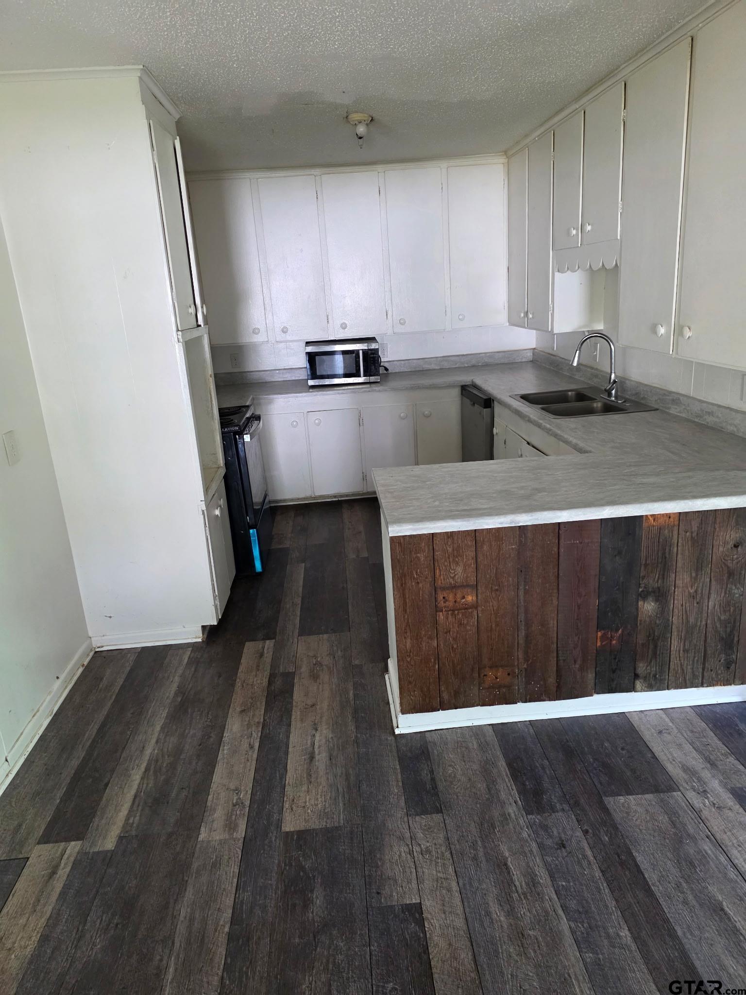 312 5th Street Southwest Bogata, TX 75417 - Photo 5 of 9 a kitchen with wooden cabinets and sink