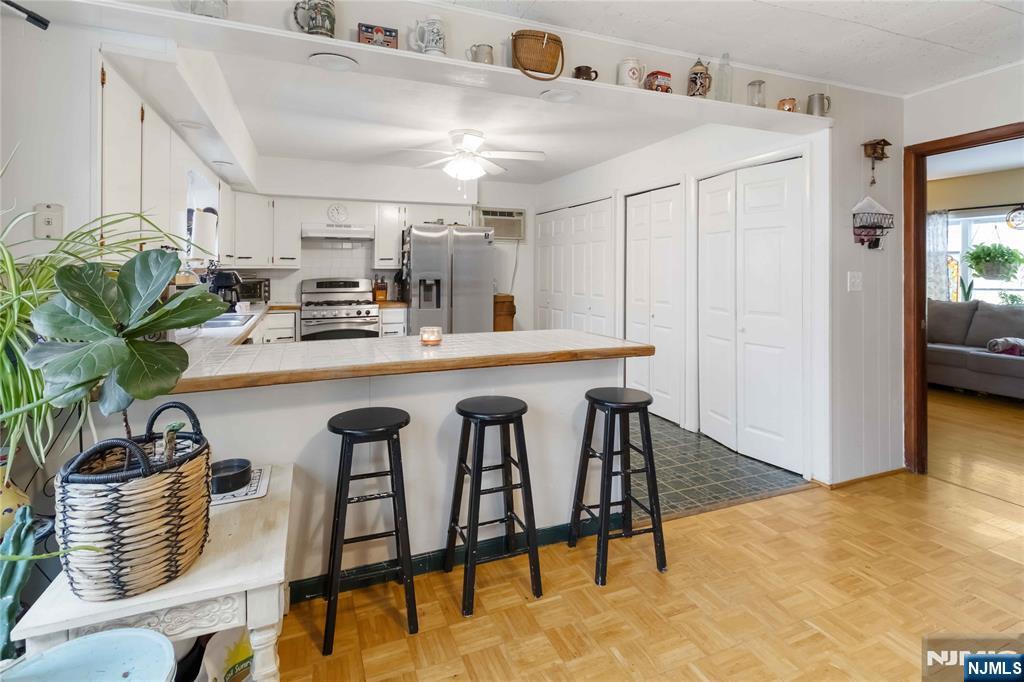 175 Highland Lakes Road Vernon, NJ 07422 - Photo 16 of 50 a kitchen with stainless steel appliances kitchen island granite countertop a table chairs and a refrigerator