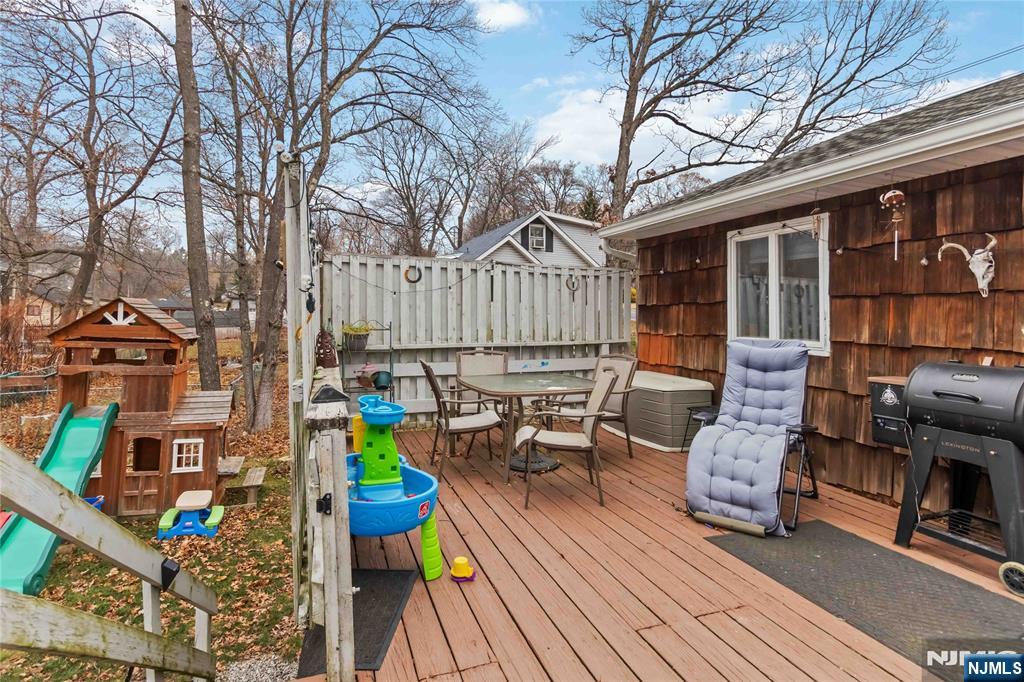175 Highland Lakes Road Vernon, NJ 07422 - Photo 35 of 50 a view of a deck with couches table and chairs with wooden floor and fence