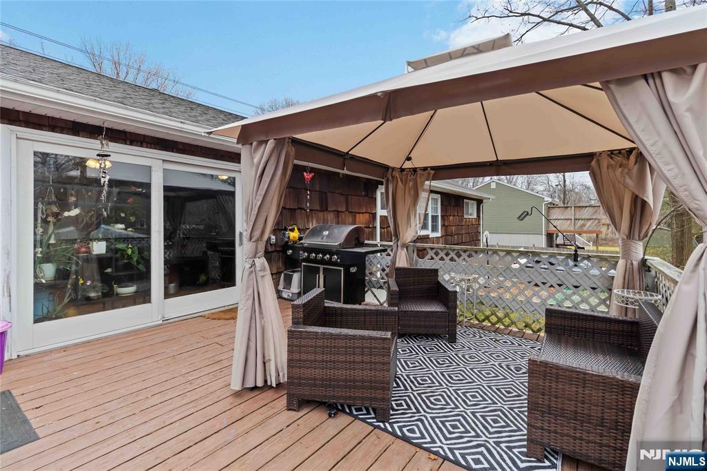 175 Highland Lakes Road Vernon, NJ 07422 - Photo 36 of 50 a view of a patio with table and chairs under an umbrella