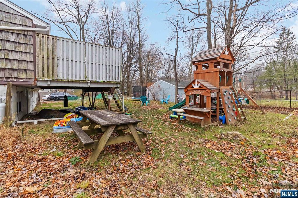 175 Highland Lakes Road Vernon, NJ 07422 - Photo 43 of 50 a backyard of a house with barbeque oven table and chairs