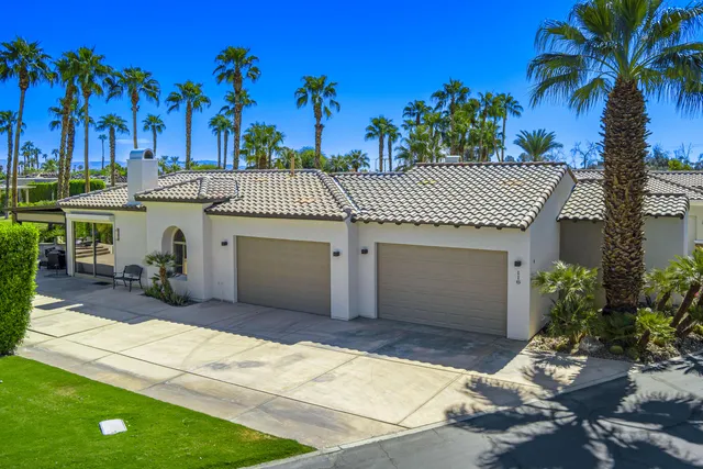 a front view of a house with a garden and a garage