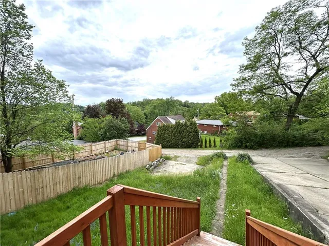 a view of a backyard with wooden fence