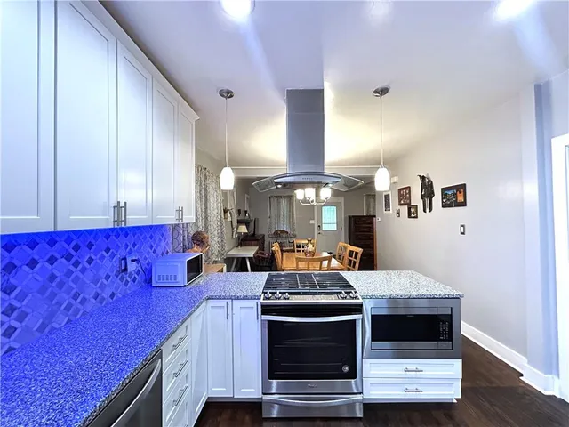a kitchen with stainless steel appliances granite countertop a stove and a microwave