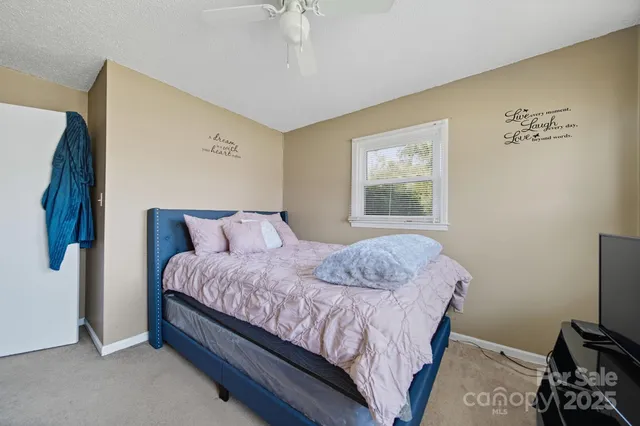 a bedroom with a bed and a flat tv screen on a dresser