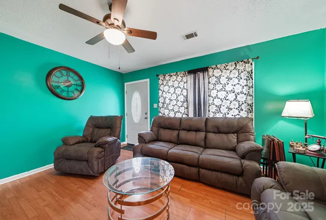 a living room with furniture a fireplace and a large window