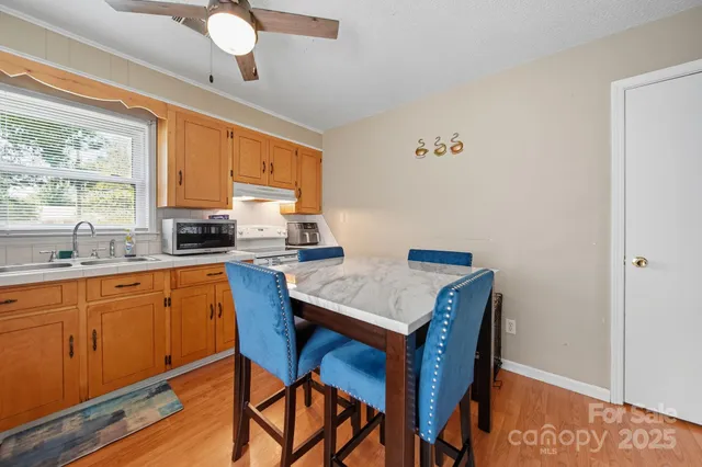 a kitchen with a table chairs a sink dishwasher window and cabinets