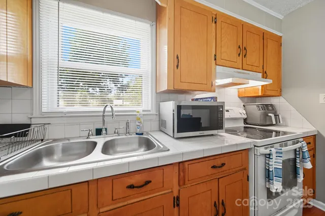 a kitchen with stainless steel appliances granite countertop a sink a stove and a microwave