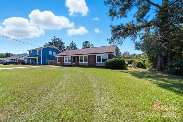 a house view with swimming pool and trees in the background