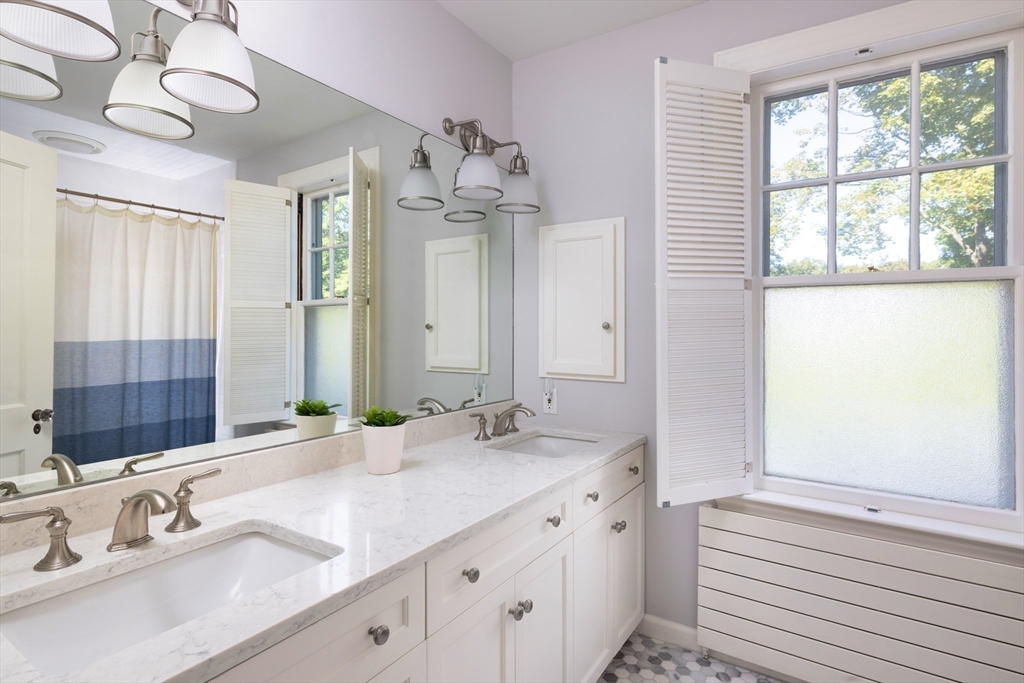 26 Dorset Road Newton, MA 02468 - Photo 17 of 22 a bathroom with a double vanity sink and a mirror