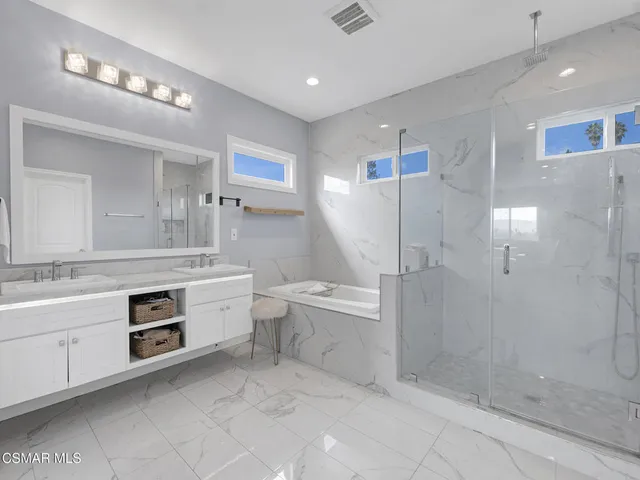 a spacious bathroom with a granite countertop sink mirror and bathtub
