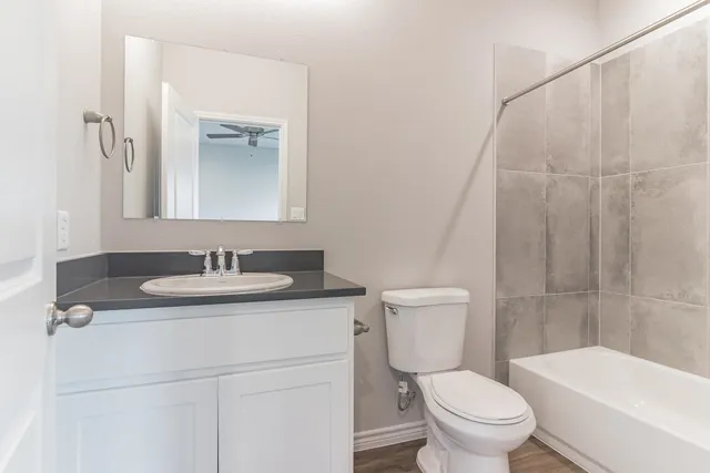 a bathroom with a sink toilet vanity and shower