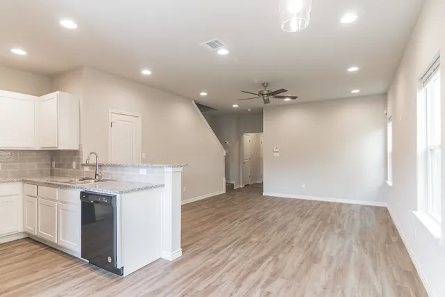 a view of a kitchen with a sink and wooden floor