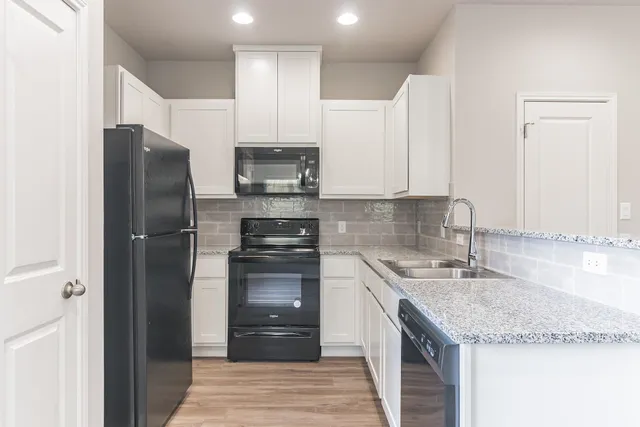 a kitchen with stainless steel appliances granite countertop a refrigerator sink and cabinets