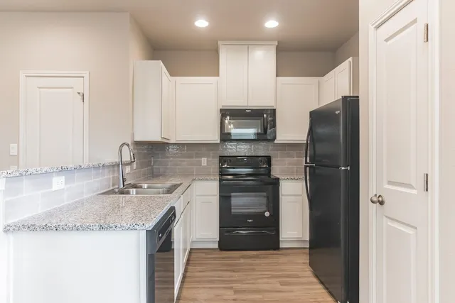 a kitchen with stainless steel appliances granite countertop a refrigerator and a sink