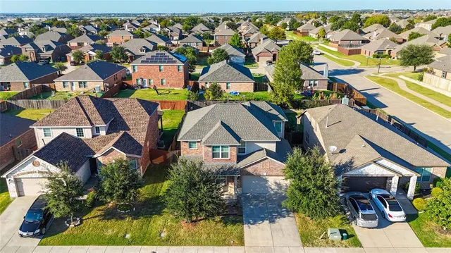 an aerial view of residential houses with outdoor space and parking