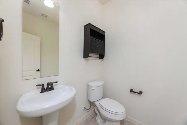 a bathroom with a toilet a sink and mirror