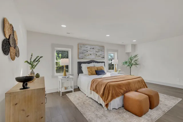 a spacious bedroom with a bed and glass windows