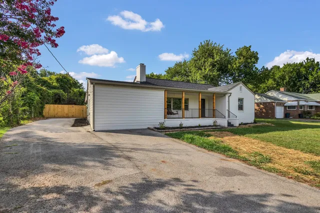 a view of a house with a yard and potted plants