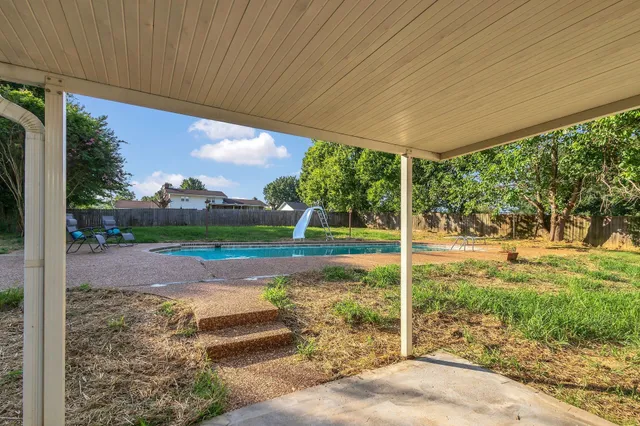 a front view of a house with a yard and trees