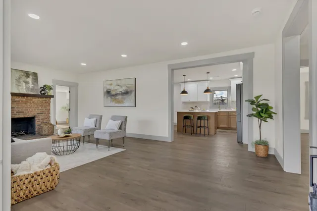 a living room with furniture and a fireplace with wooden floor