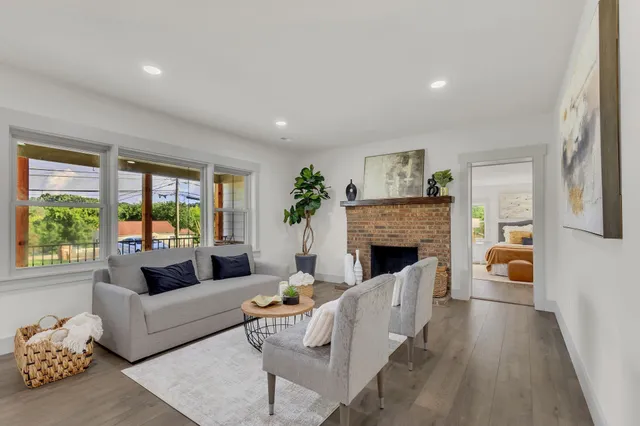 a living room with furniture large window and a fireplace