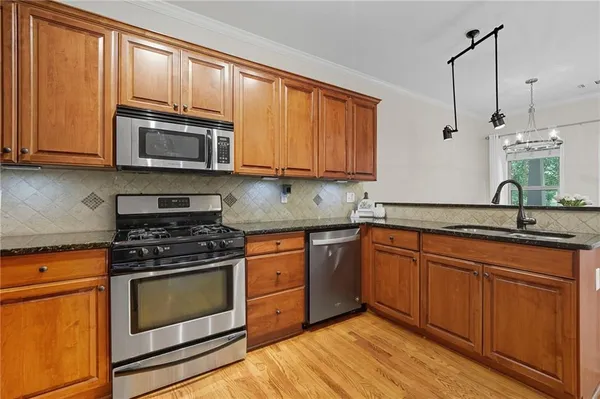 a kitchen with granite countertop a sink and wooden cabinets