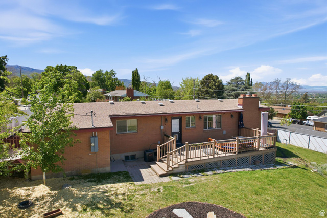 935 900 North Bountiful, UT 84010 - Photo 44 of 46 Rear view of house featuring a deck with mountain view, a chimney, a patio area, and brick siding