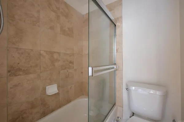 a bathroom with a granite countertop shower and a toilet